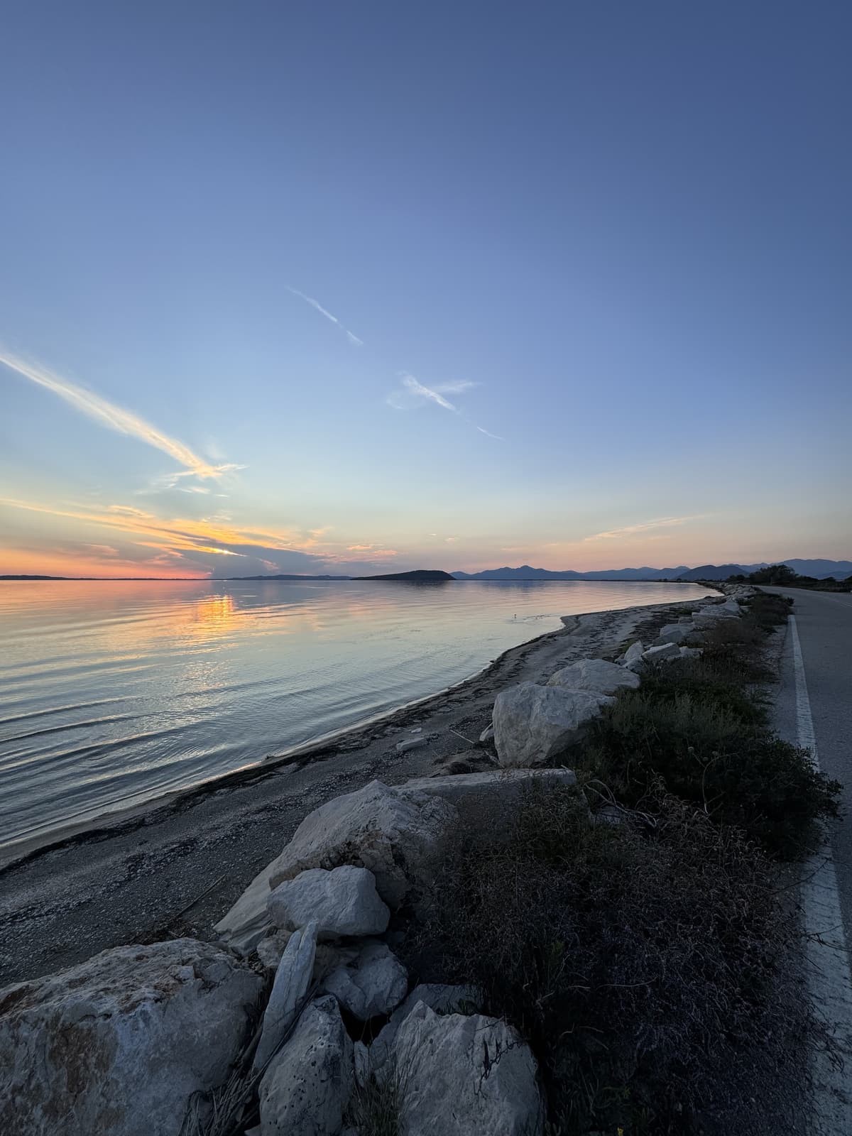 Natural coastal perspective with sunset sky and rocky shoreline