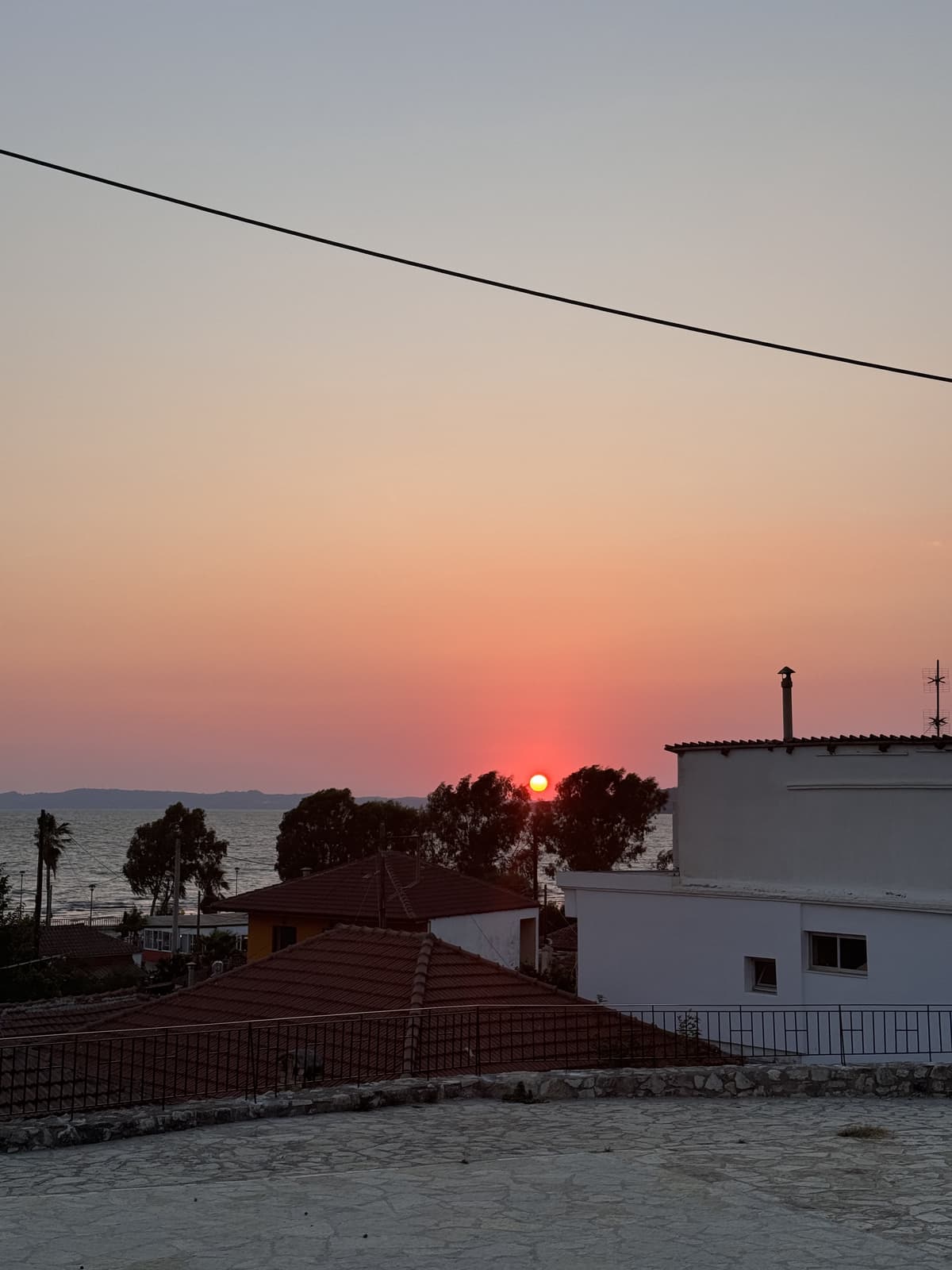 Urban-coastal sunset over Mediterranean rooftops