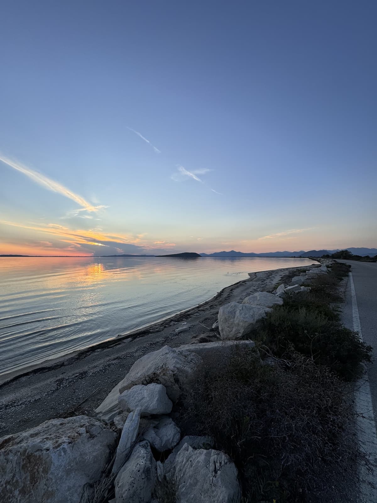 Natural coastal perspective with sunset sky and rocky shoreline